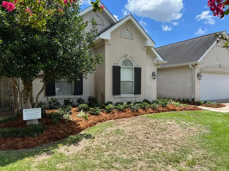 Lush garden bed with vibrant flowering plants and neatly trimmed shrubbery, meticulously maintained by Southern Grounds LLC in Marrero, LA.