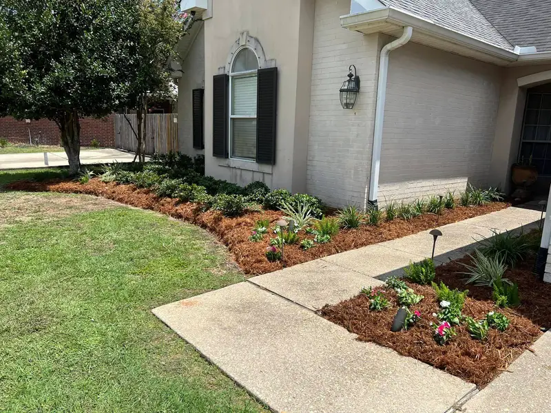 Lush garden bed with vibrant flowering plants and neatly trimmed shrubbery, meticulously maintained by Southern Grounds LLC in Marrero, LA.
