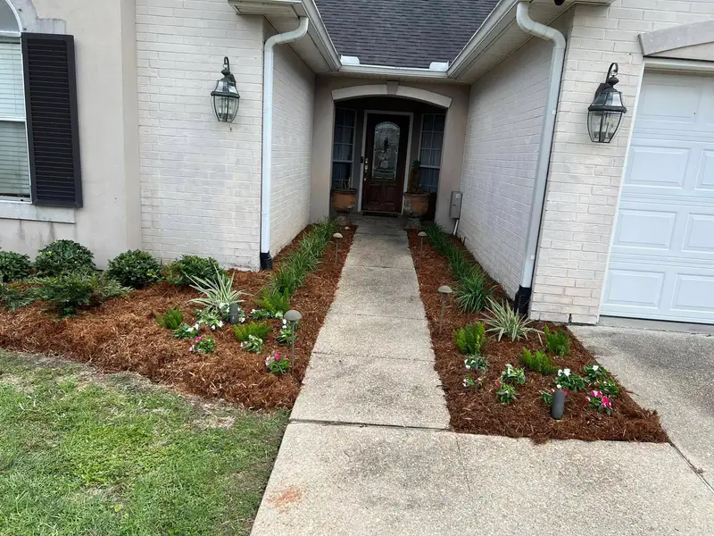 Lush garden bed with vibrant flowering plants and neatly trimmed shrubbery, meticulously maintained by Southern Grounds LLC in Marrero, LA.