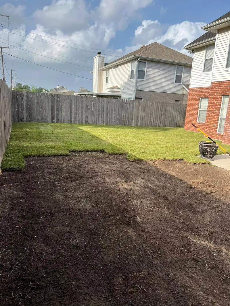 A residential backyard prepared for new sod installation, featuring bare soil ready for transformation, serviced by Southern Grounds LLC.