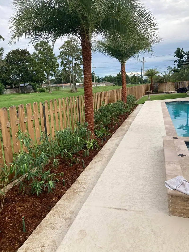 Elegant residential garden landscaped by Southern Grounds LLC, featuring a balanced combination of evergreens and seasonal flowers in New Orleans.