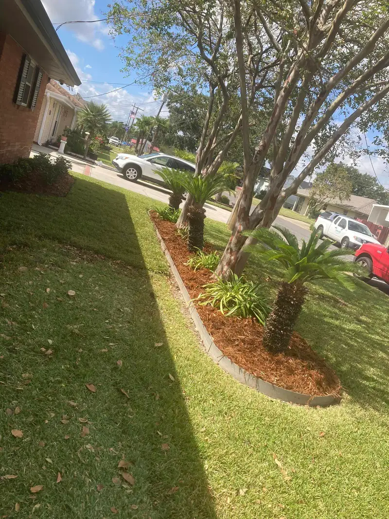 Professional landscaping services by Southern Grounds LLC featuring vibrant flower beds and neatly trimmed lawns in a New Orleans home.