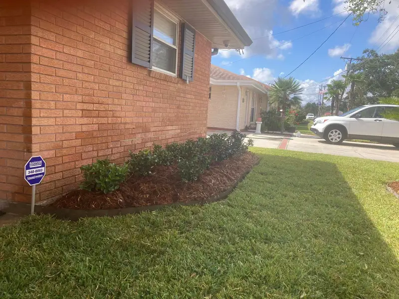 Professional landscaping services by Southern Grounds LLC featuring vibrant flower beds and neatly trimmed lawns in a New Orleans home.