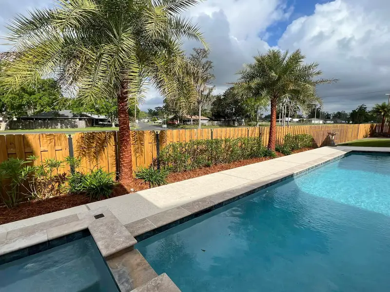 Elegant residential garden landscaped by Southern Grounds LLC, featuring a balanced combination of evergreens and seasonal flowers in New Orleans.