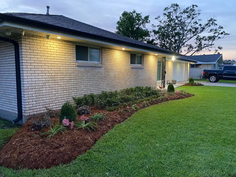 Expertly designed backyard landscape with a variety of lush green plants and trees, showcasing Southern Grounds LLC's attention to detail in New Orleans.