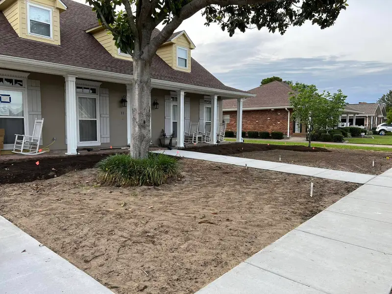 Elegant residential garden landscaped by Southern Grounds LLC, featuring a balanced combination of evergreens and seasonal flowers in New Orleans.