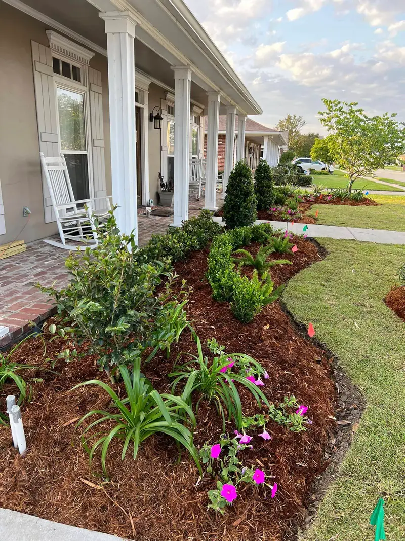 Elegant residential garden landscaped by Southern Grounds LLC, featuring a balanced combination of evergreens and seasonal flowers in New Orleans.