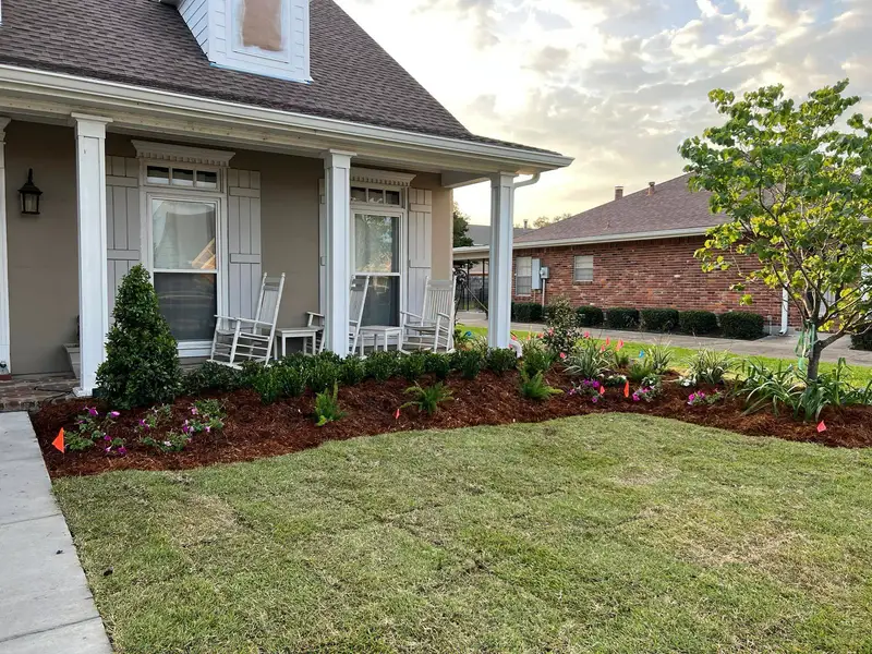Elegant residential garden landscaped by Southern Grounds LLC, featuring a balanced combination of evergreens and seasonal flowers in New Orleans.