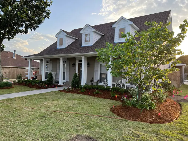 Elegant residential garden landscaped by Southern Grounds LLC, featuring a balanced combination of evergreens and seasonal flowers in New Orleans.