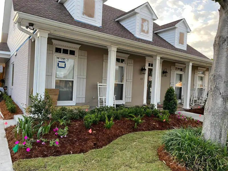 Elegant residential garden landscaped by Southern Grounds LLC, featuring a balanced combination of evergreens and seasonal flowers in New Orleans.