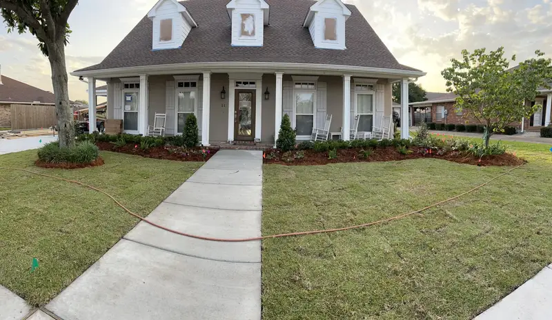 Elegant residential garden landscaped by Southern Grounds LLC, featuring a balanced combination of evergreens and seasonal flowers in New Orleans.