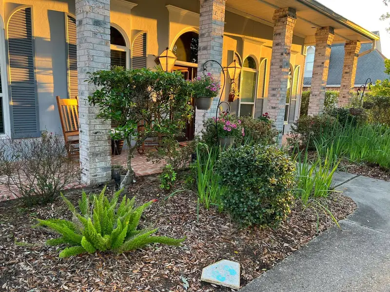 Professional landscaping services by Southern Grounds LLC featuring vibrant flower beds and neatly trimmed lawns in a New Orleans home.
